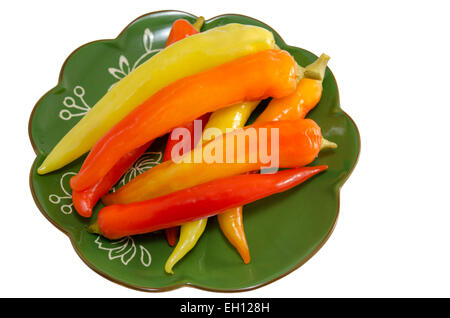 Eingelegte Paprika auf einer grünen Platte isoliert auf weiss Stockfoto