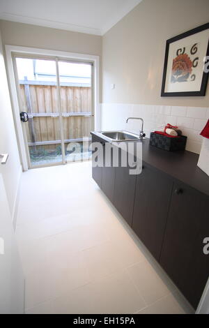 Moderne Waschküche mit Fliesen Boden und Glas Tür Stockfoto