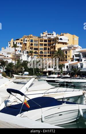 Motorboote im Innenhafen mit Bars, Restaurants und Wohnungen an der Rückseite, Puerto Cabopino, Costa Del Sol, Spanien. Stockfoto