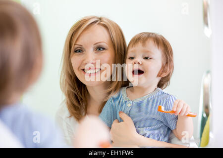 Mutter lehrt Kinder Zähne putzen Stockfoto