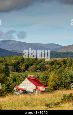 Holzhütte mit einem roten Dach in einer ländlichen Gegend der Cairngorms, Schottland unter einem Himmel bewölkt Herbst Herbst Stockfoto