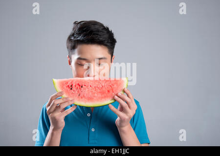 Junger Mann Essen Wassermelone Stockfoto