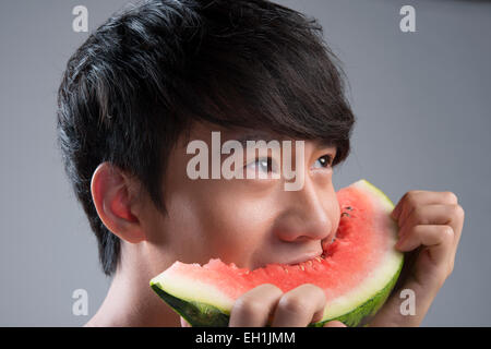 Junger Mann Essen Wassermelone Stockfoto