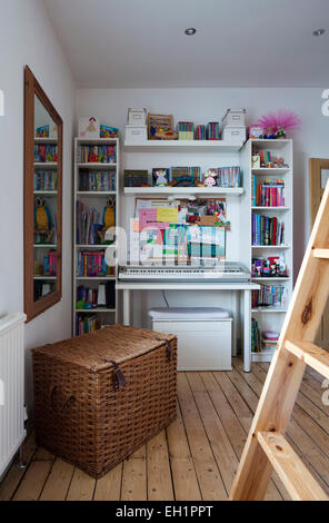 Bücherregal und Wäschekorb im Kinderzimmer von Macclesfield Stadthaus, Cheshire, England, UK Stockfoto