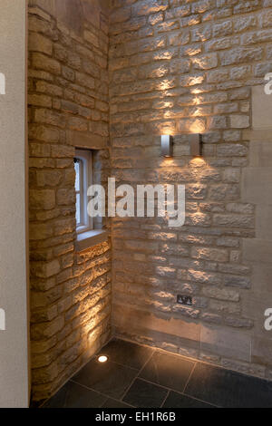 Detail der beleuchteten Steinmauer und vertieften Boden Deckenstrahler. Merton College, Universität Oxford, Hörsaal und Rezeption Bereich. Stockfoto