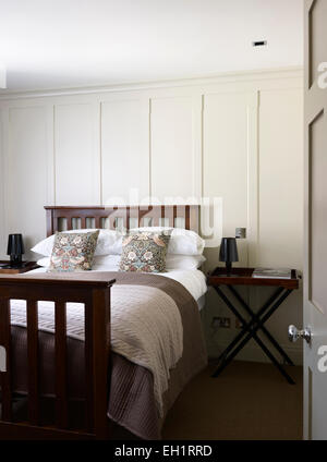 Doppelbett in weiß gestrichenen getäfelten Schlafzimmer, Wohn-Haus, Burlington Road, London, England, UK Stockfoto