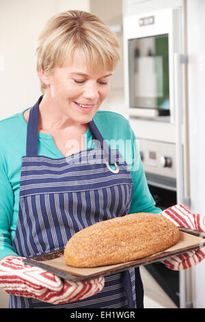 Frau hausgemachtes Einnahme Brot aus dem Ofen Stockfoto