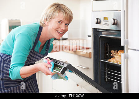 Frau, gebratenes Huhn im Ofen kochen Stockfoto