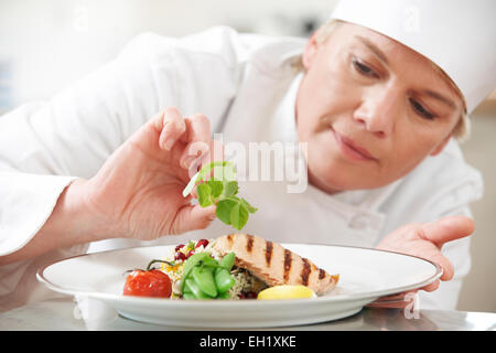 Koch, Essen im Restaurant Küche Garnitur hinzufügen Stockfoto