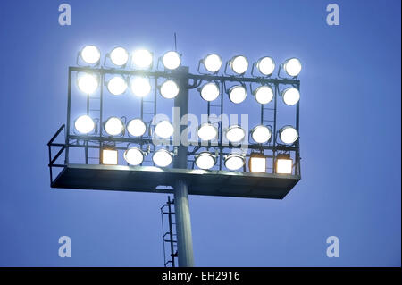 Fußball-Stadion-Scheinwerfer eingeschaltet bei Sonnenuntergang Stockfoto