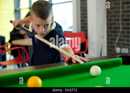 Bei einem Jugendprojekt in Rogerfield und Easterhouse; Unter 12 Jahren spielen auf dem Billardtisch Stockfoto