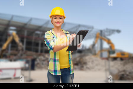 lächelnde Frau in Helm mit Zwischenablage Stockfoto