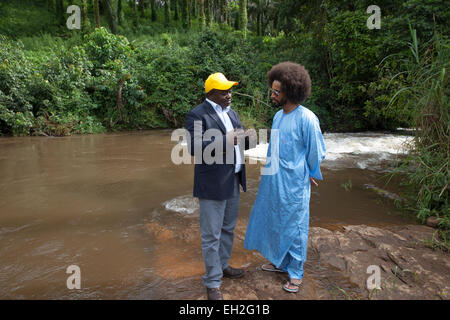 Dr. Joseph Oye erklärt Fußballer Benoit Rohrspatz-Ekotto, wird durch eine Fliege in der Nähe von schnell fließenden Flüssen wie Flussblindheit verbreitet. Stockfoto