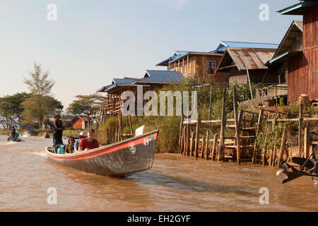 Touristen, die mit einem Boot fahren durch ein Dorf am Inle-See, Myanmar (Burma), Asien Stockfoto