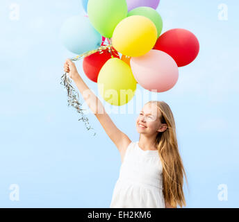 glückliches Mädchen mit bunten Luftballons Stockfoto