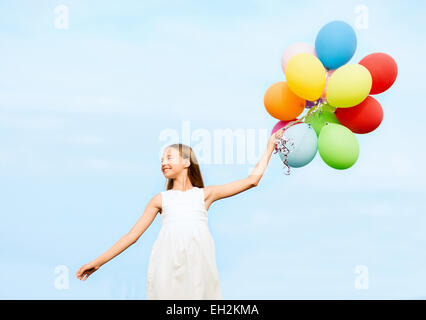 glückliches Mädchen mit bunten Luftballons Stockfoto