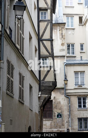 Ein altes Fachwerkhaus Gebäude ragt in eine Straße im Marais Bezirk von Paris, Frankreich Stockfoto