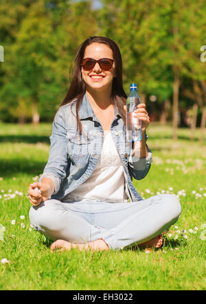 lächelnd junges Mädchen mit Flasche Wasser im park Stockfoto