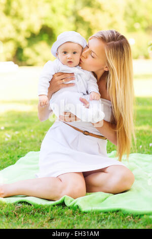 glückliche Mutter mit Baby sitzen auf Decke Stockfoto