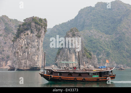 Dschunke, Segeln unter Karst Kalkbergen im Cat Ba Nationalpark, Ha long, Halong Bay, Ha long, Halong Bucht, Vietnam Stockfoto
