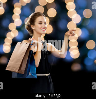 lächelnde Frau in Tracht mit Einkaufstüten Stockfoto
