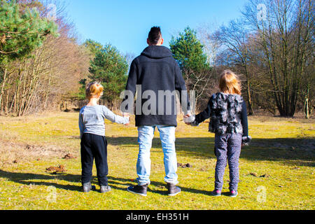 zwei Mädchen und ein großer Bruder Hand in Hand Stockfoto
