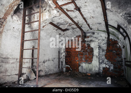 Alte leere verlassenen Bunker Innenraum mit weißen Wänden und verrosteten Konstruktionen Stockfoto