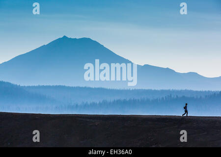 Wanderer, die Silhouette gegen Lassen Peak während am Rand des Schlackenkegel, Lassen Nationalpark, Kalifornien, USA Stockfoto