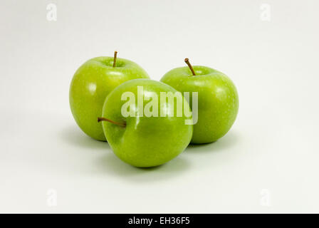 Drei grüne Granny Smith Äpfel auf weißem Hintergrund angeordnet Stockfoto
