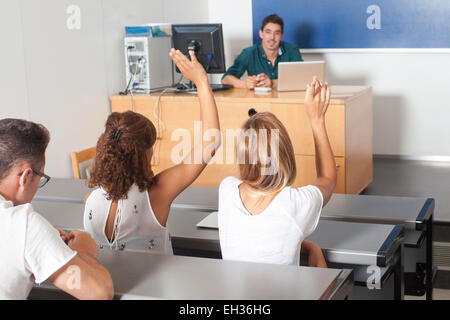 Studenten eine Frage beantworten und ihre Hände aufstellen Stockfoto