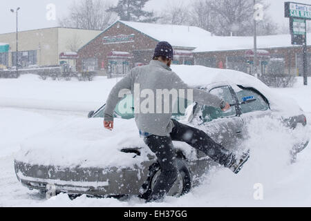 Lexington, Kentucky, USA. März 2015. Ein nicht identifizierter Autofahrer wirft Schnee von seinem Auto weg, während er versucht, ihn auszugraben, nachdem er am Donnerstag, 5. März 2015 in Lexington, KY, USA, von der New Circle Road in das Einkaufszentrum Bryan Station Kroger einbiegt. Der Gouverneur erklärte zum zweiten Mal innerhalb von 17 Tagen einen landesweiten Notfall, nachdem ein Wintersturm in weniger als 17 Stunden bis zu 21 Zoll Schnee auf den Staat abwarf, einschließlich eines neuen Rekordauftrags von 17.1 Zoll in Lexington, Kentuckys zweitgrößter Stadt. (APEX MediaWire Foto von Billy Suratt) Stockfoto