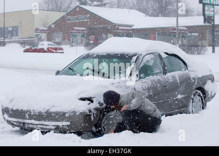 Lexington, Kentucky, USA. März 2015. Ein nicht identifizierter Autofahrer gräbt sein Auto aus dem Schnee, nachdem er am Donnerstag, den 5. März 2015 in Lexington, KY, USA, von der New Circle Road in das Einkaufszentrum Bryan Station Kroger einbiegen konnte. Der Gouverneur erklärte zum zweiten Mal innerhalb von 17 Tagen einen landesweiten Notfall, nachdem ein Wintersturm in weniger als 17 Stunden bis zu 21 Zoll Schnee auf den Staat abwarf, einschließlich eines neuen Rekordauftrags von 17.1 Zoll in Lexington, Kentuckys zweitgrößter Stadt. (APEX MediaWire Foto von Billy Suratt) Stockfoto