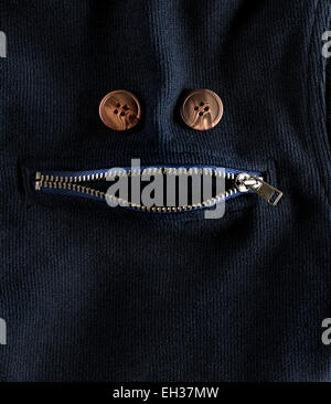 Reißverschluss und Knöpfe auf Stoff, die aussehen wie Gesicht Stockfoto
