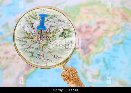 Blauen Stift auf der Weltkarte mit Lupe suchen in Minsk, Belarus Stockfoto