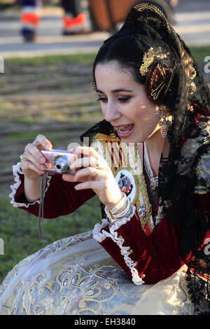 Eine junge Dame in traditionellen Las Fallas Festival Kleid und Kopfbedeckung nehmen Foto Stockfoto