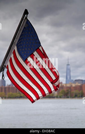 Amerikanische Flagge mit Skyline von New York City und East River im Hintergrund, New York, USA Stockfoto