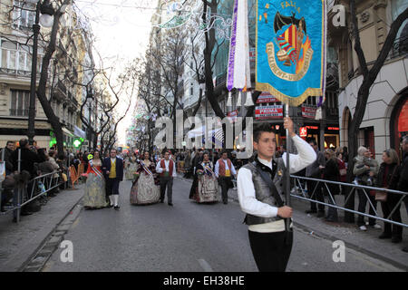 Ein junger Mann in traditionellen Las Fallas Festival Kleid hält einen Banner führt eine Prozession Stockfoto