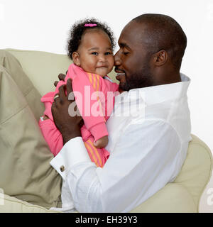 Porträt von Vater und Babymädchen auf Stuhl, Studioaufnahme Stockfoto