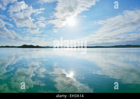 Blauer Himmel, Wolken und Sonne spiegelt sich im See, See Woerthsee, Bayern, Deutschland Stockfoto