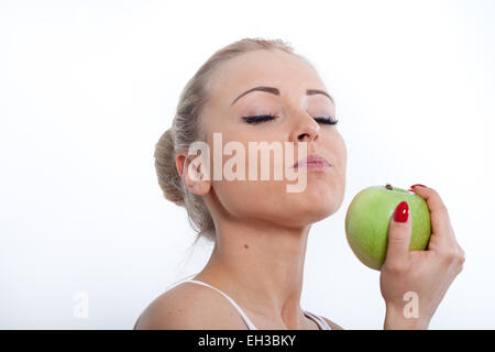 schöne junge blonde Mädchen Verkostung einen wunderschönen roten Apfel Stockfoto