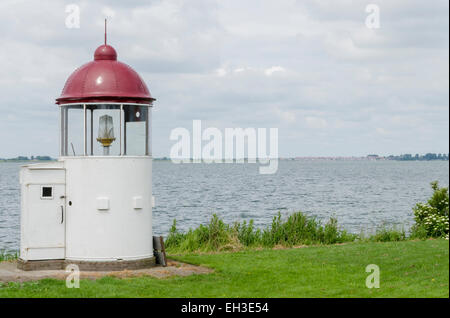 Kleine weiße und rote Leuchtturm am Marken in der Nähe der Gouwzee. Stockfoto