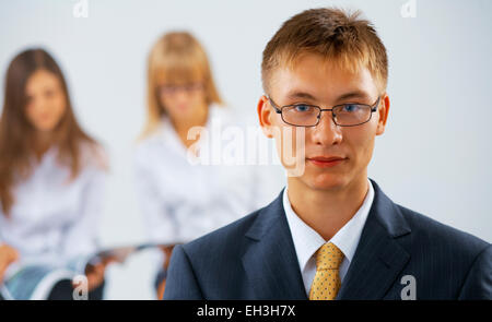 Porträt des jungen ernst Mann mit zwei Frauen auf dem Hintergrund Stockfoto
