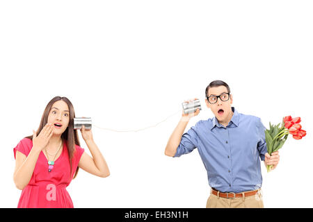 Mann und Frau sprechen durch eine Blechdose Telefon isoliert auf weißem Hintergrund Stockfoto