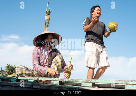 Ein Mann und eine Frau zu verkaufen, Kokosnuss und Ananas am Mekong-Delta, Vietnam Stockfoto