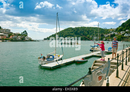 Ein junge weibliche Angler versucht ihr Glück den Fluss Dart aus dem Süden Damm in Dartmouth, Devon, England, UK Stockfoto