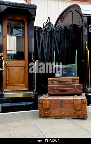 Gepäck auf einem Hand-Wagen an der Seite einen vergoldeten LNWR First Class schlafenden Eisenbahn Coach. Stockfoto