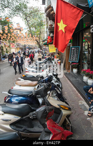 Roller auf Bürgersteig und Vietnam Flagge geparkt. , Umweltverschmutzung, Lärm, Verkehr, Ha Noi, Hanoi, Vietnam Stockfoto