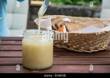 Tropfen Honig aus einem Messer in eine jar-Abblendlicht Stockfoto