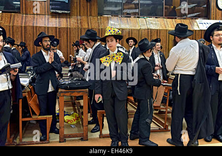 Eine Gruppe von religiösen jüdischen Männern einschließlich einer in einem Purim-Kostüm auf eine Synagoge in Brooklyn, New York. Stockfoto