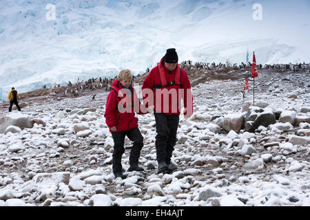 Antarktis, Neko Harbour, Kreuzfahrt-Passagiere zu Fuß rund um Gentoo-Pinguin-Kolonie im Schnee Stockfoto